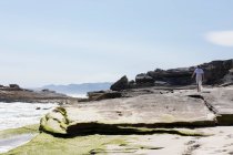 Teenage girl exploring a rocky shore on the Atlantic ocean coastline — Foto stock