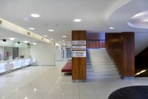 Espace d'attente et réception dans un hôpital moderne, avec panneaux et escaliers — Photo de stock