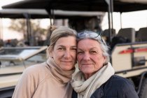 Due donne affiancate da un veicolo safari, donna adulta e sua madre, somiglianza familiare — Foto stock