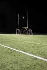 Una palla bianca tra i pali di un campo sportivo, segnando — Foto stock