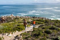 Two children walking along a coastal path to rock formations — Stock Photo