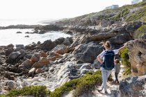 Девочка-подросток и младший брат, путешествующие по прибрежной тропе Де Келдерс, Южная Африка — стоковое фото