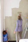 Eine Frau dekoriert einen Raum, streicht Wände. — Stockfoto