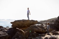 Adolescente e irmão mais novo caminhando em uma trilha costeira junto ao oceano — Fotografia de Stock