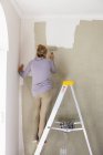 Жінка, що прикрашає кімнату, малює стіни . — стокове фото
