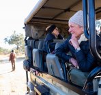 Senior woman seated in a safari jeep looking out. — Stock Photo