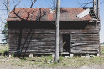 Homestead de madeira abandonada com um telhado de lata enferrujado. — Fotografia de Stock