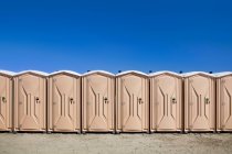 Портативные туалеты на пляже, подряд. — стоковое фото