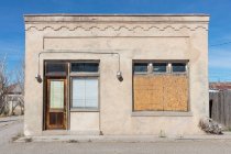 Abandoned building facade, boarded up windows and stonework pattern. — Stock Photo
