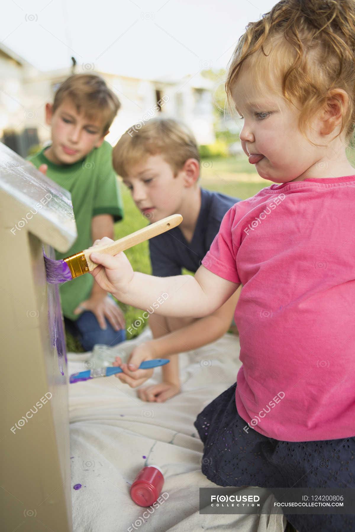 Three children painting dog house — concentration, female Stock Photo