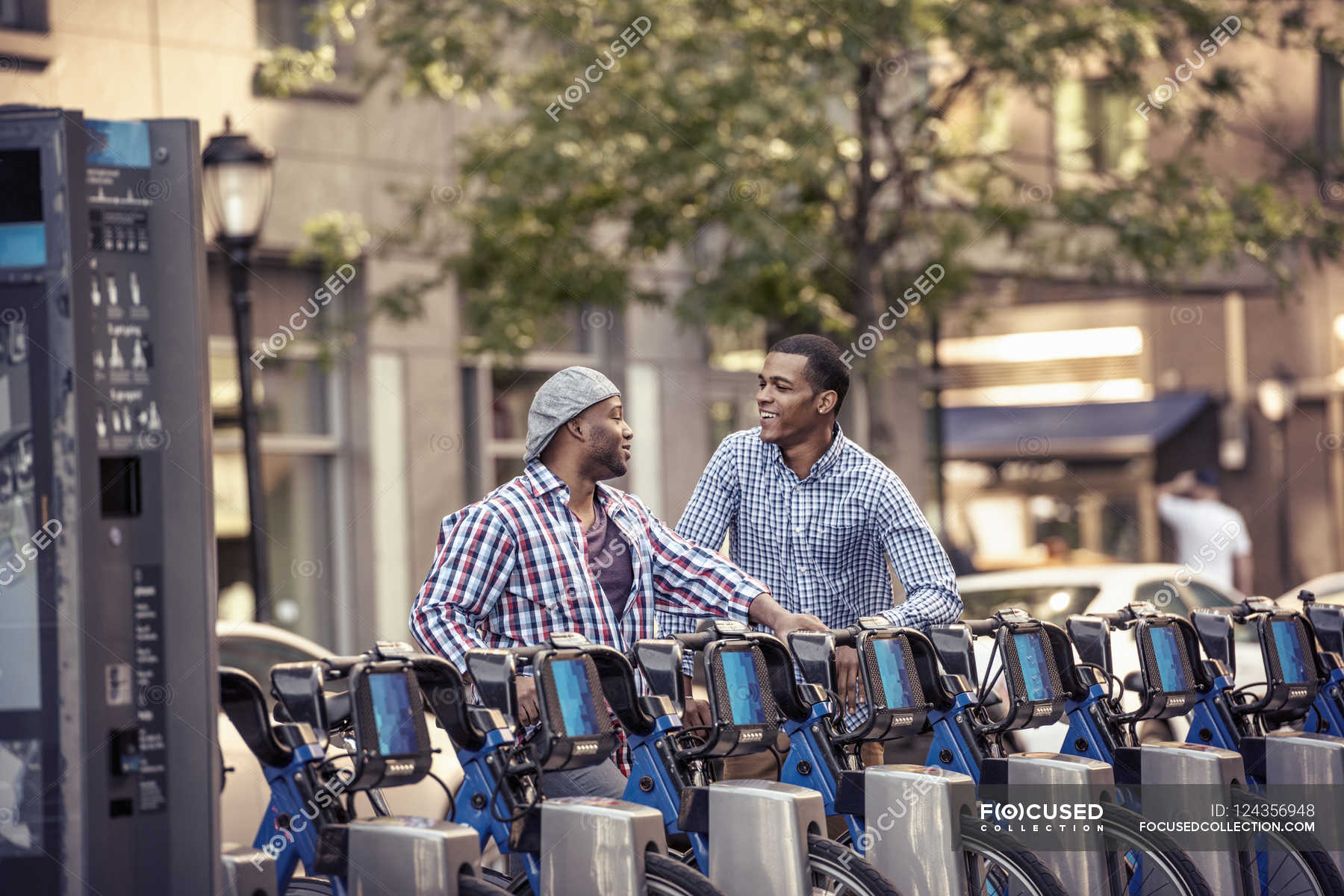 Men By A Rack Of Bicycles For Hire — Waist Up, Mixed Race Person 