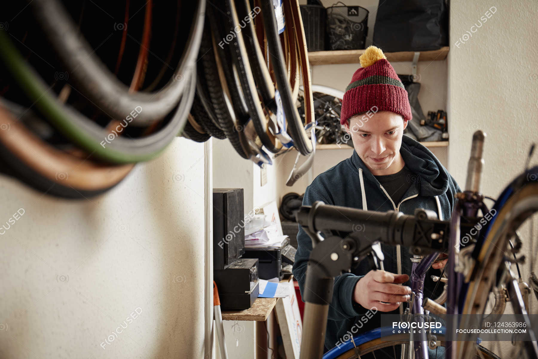 Man repairing a bicycle in cycle shop — service, hat - Stock Photo ...