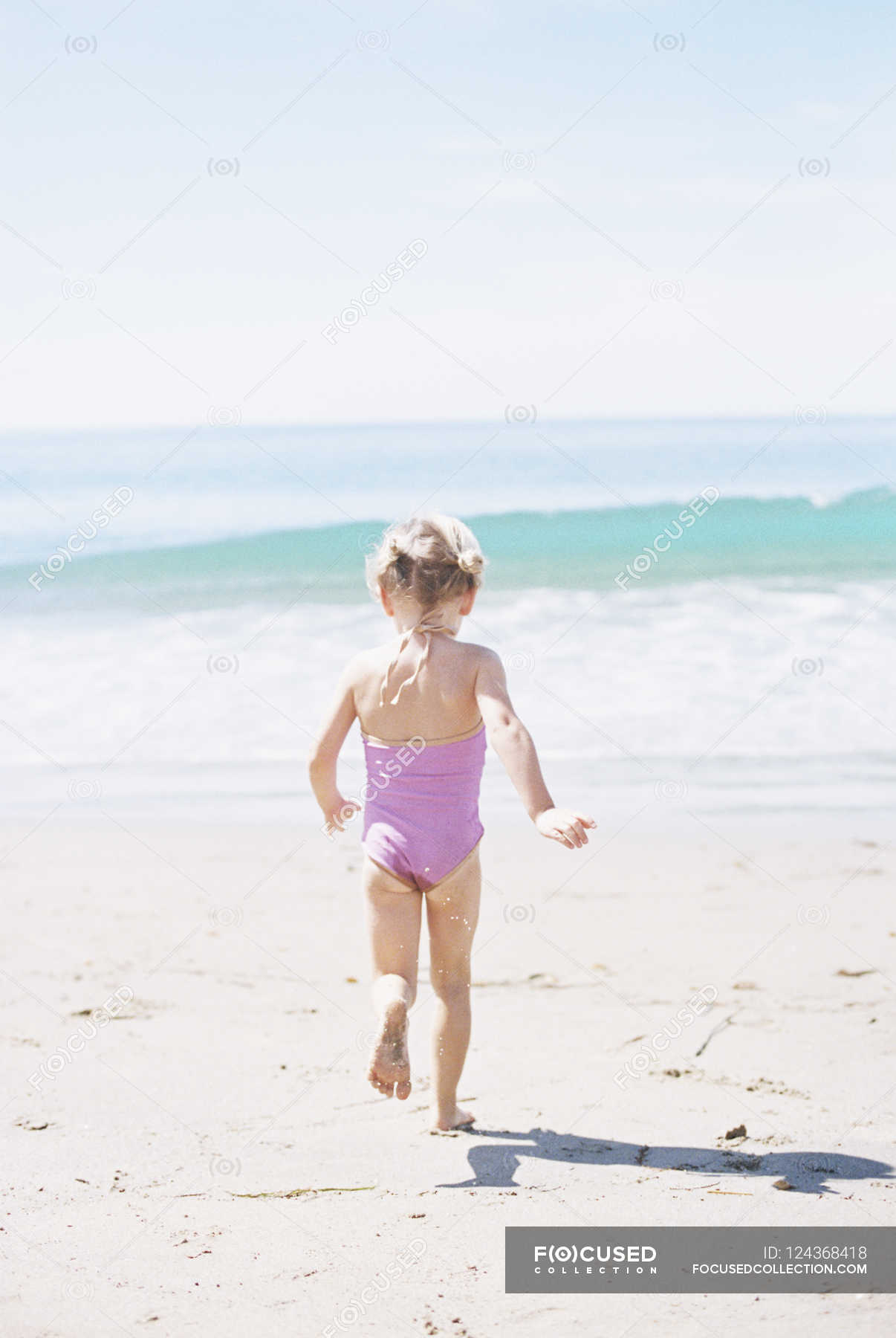 Young Girl In A Pink Swimsuit Running Full Length Blond Hair Stock Photo