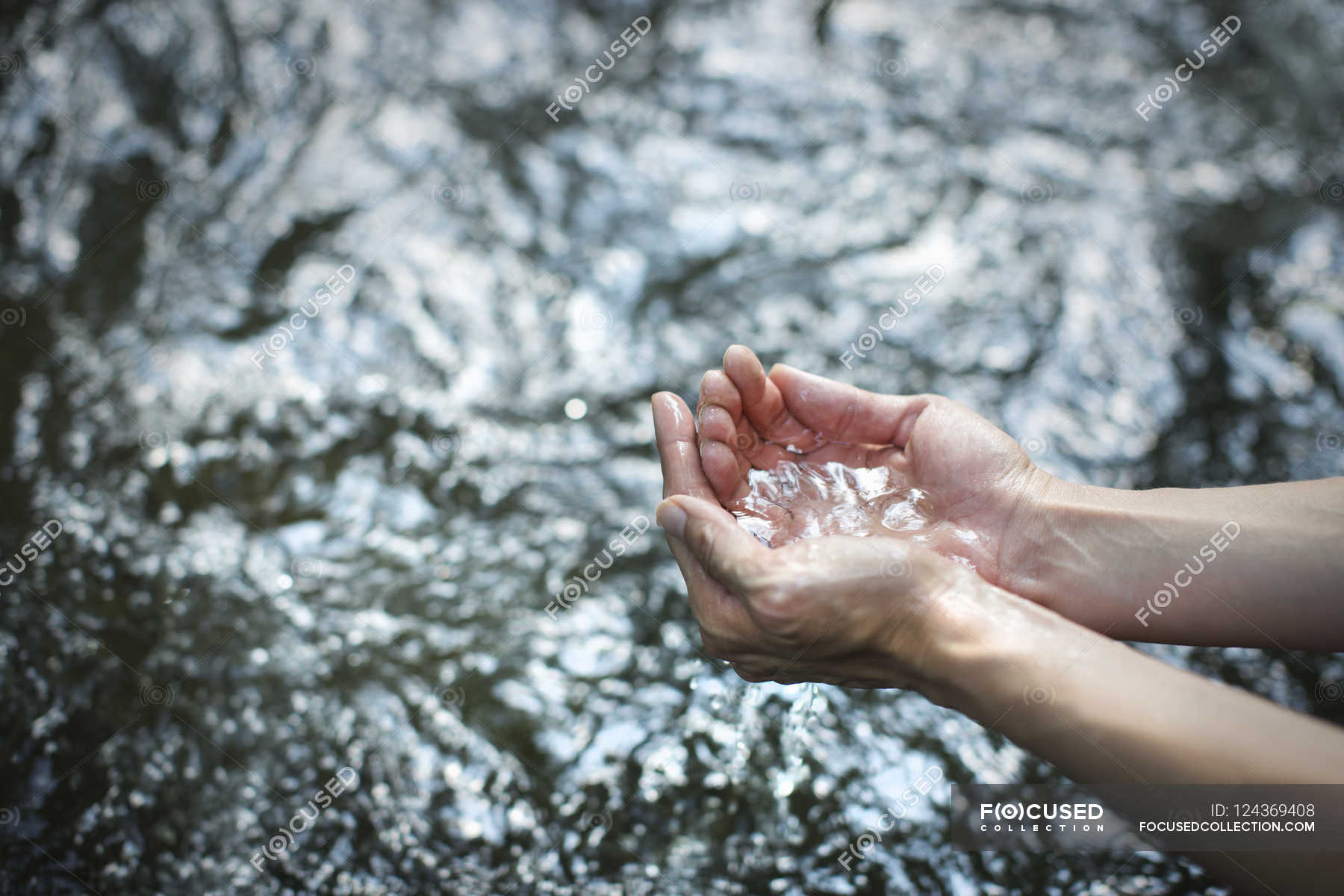 Man scooping up water — High Angle View, purity Stock Photo 124369408