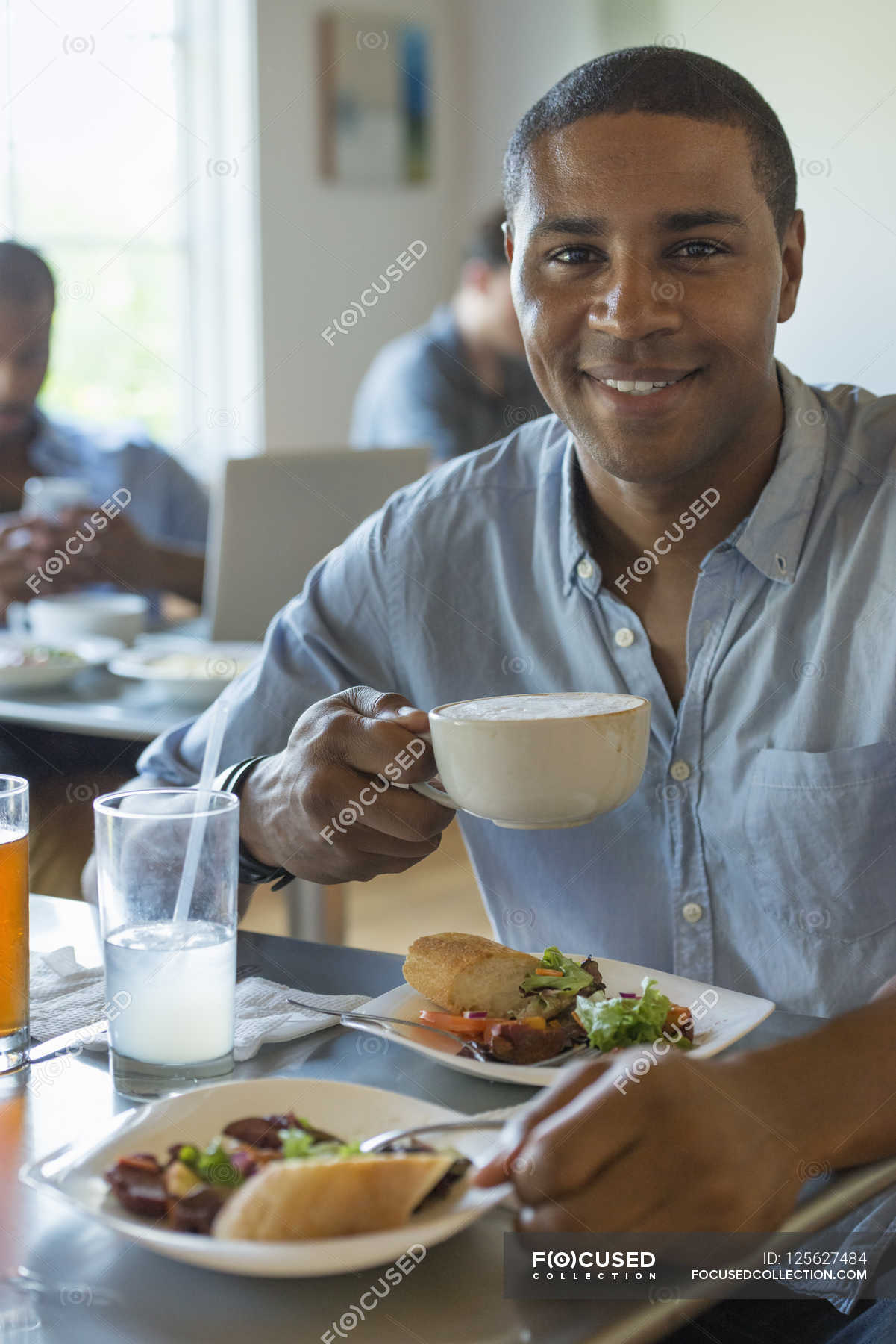 man-eating-and-drinking-in-cafe-mid-adult-man-summer-stock-photo