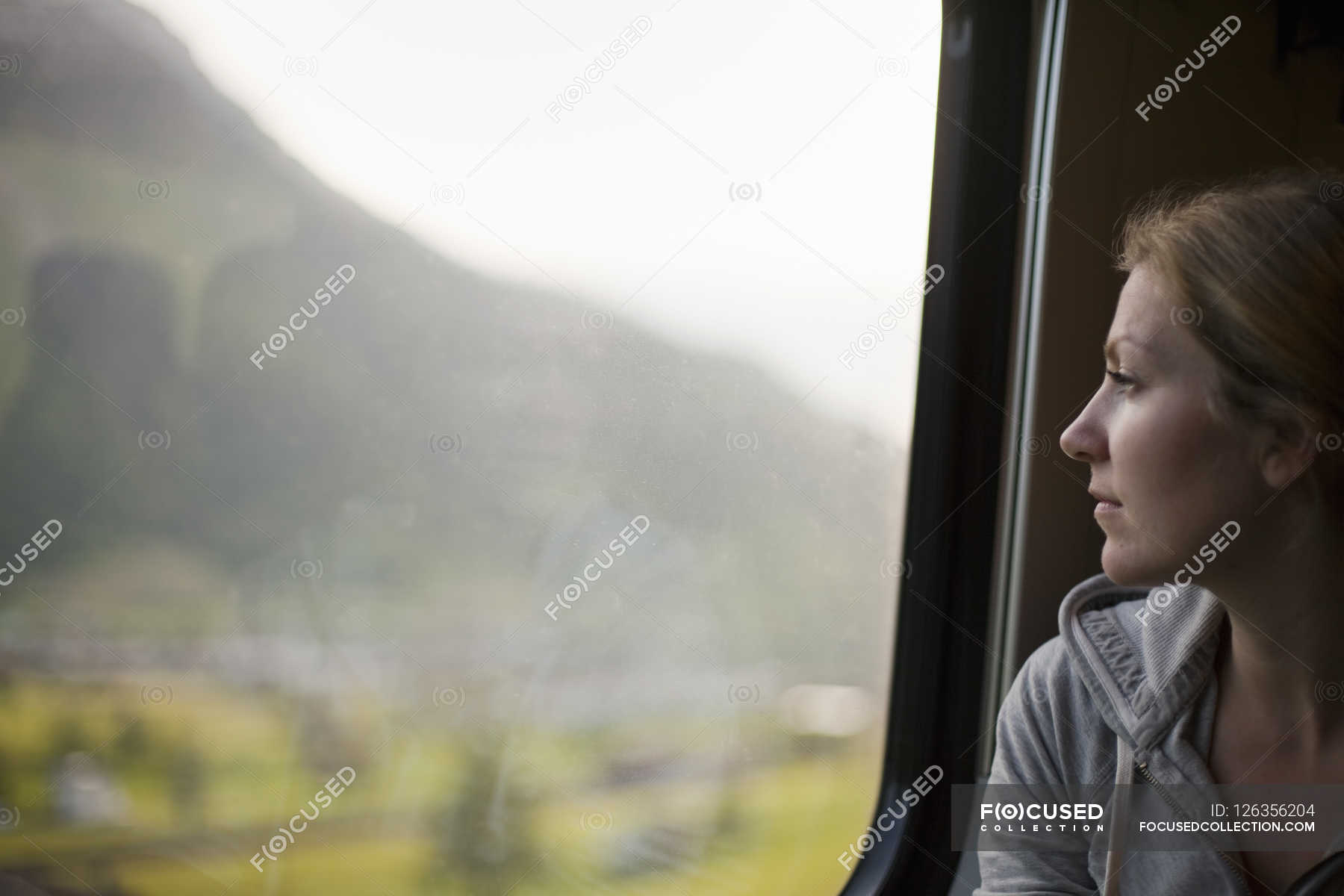 Женщина едет в поезде сидит у окна