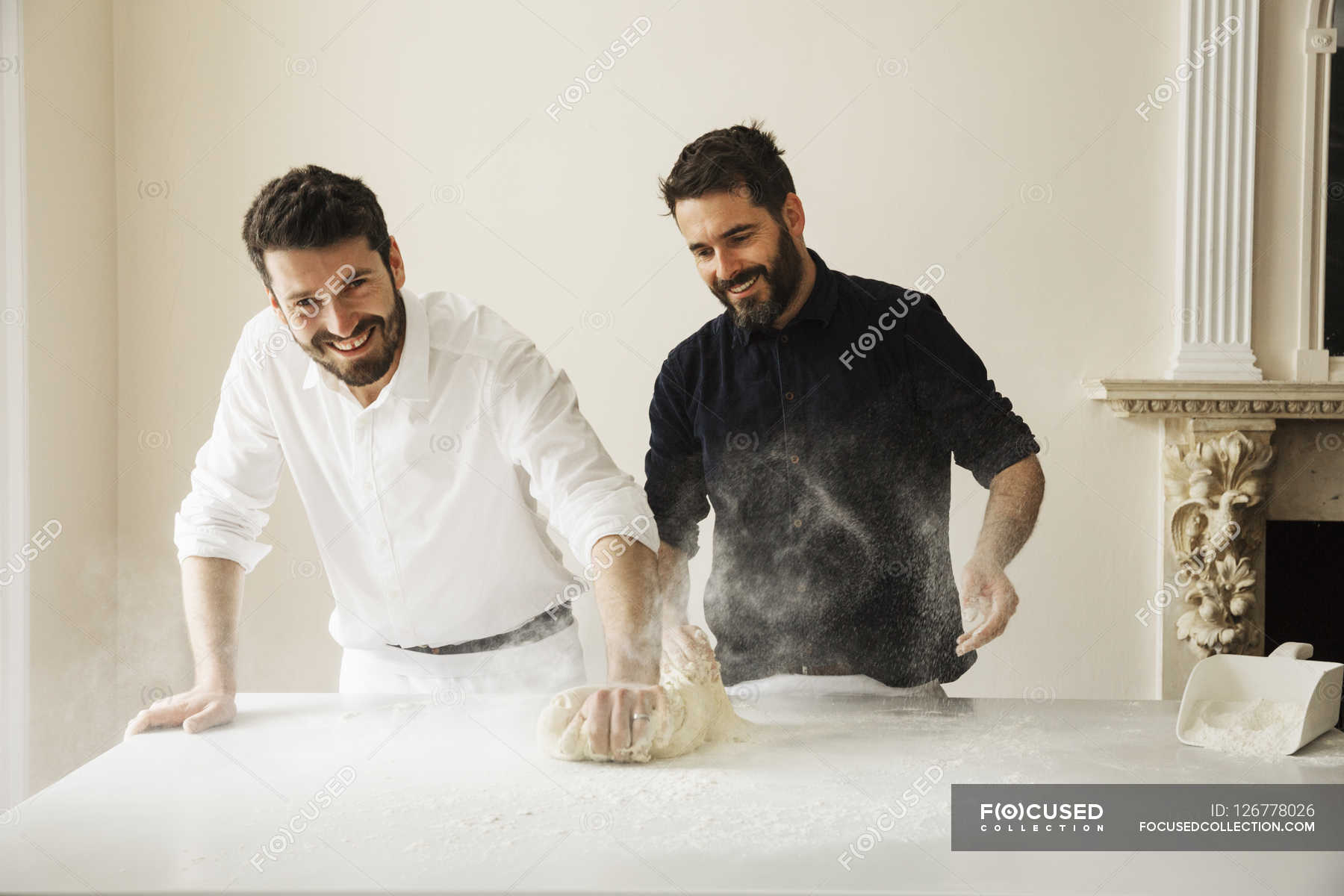 Bakers dusting bread dough with flour — teamwork, Mid Adult Men Stock Photo 126778026