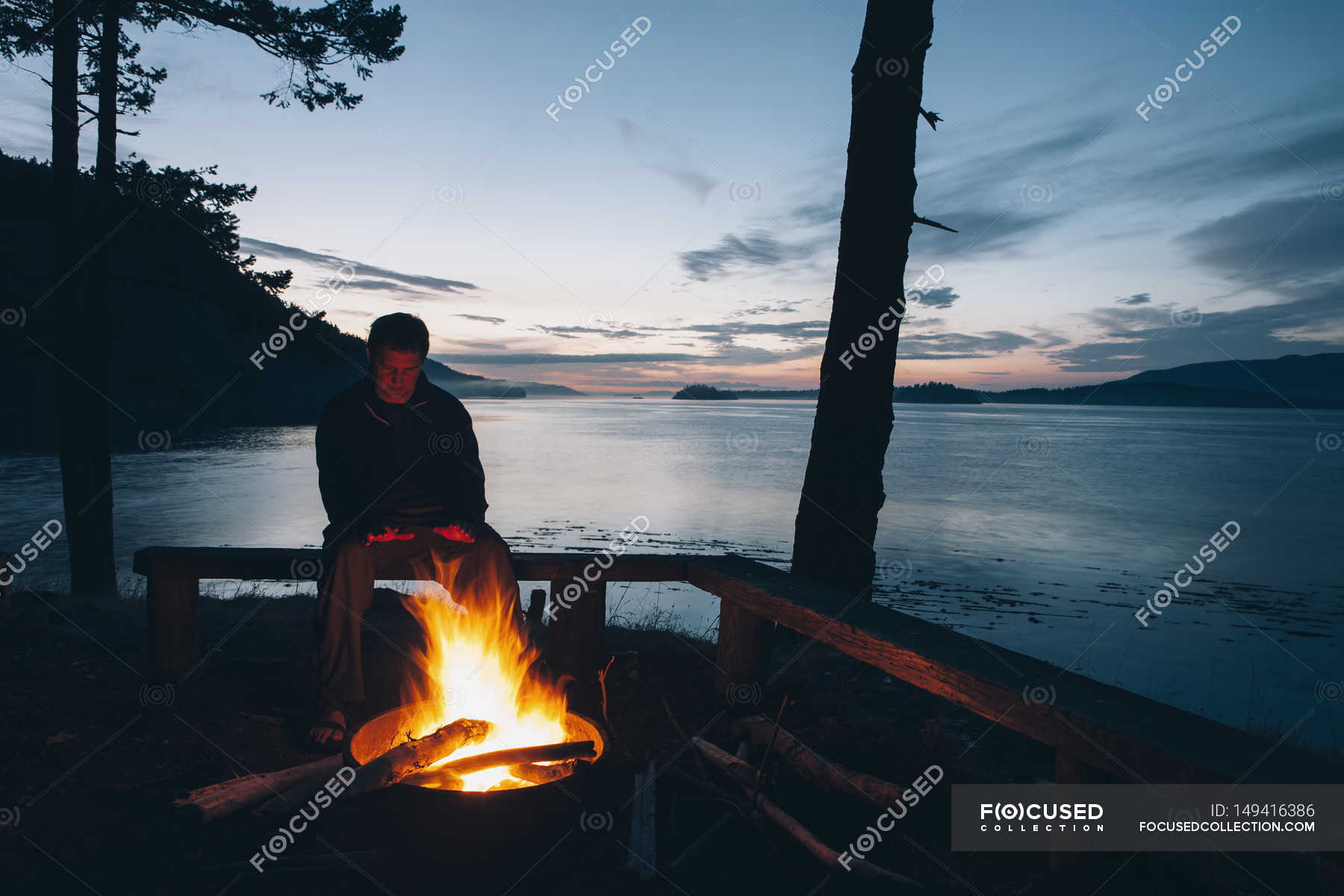 Man Sitting By Campfire At Dusk Horizontal Male Stock Photo   Focused 149416386 Stock Photo Man Sitting By Campfire At 