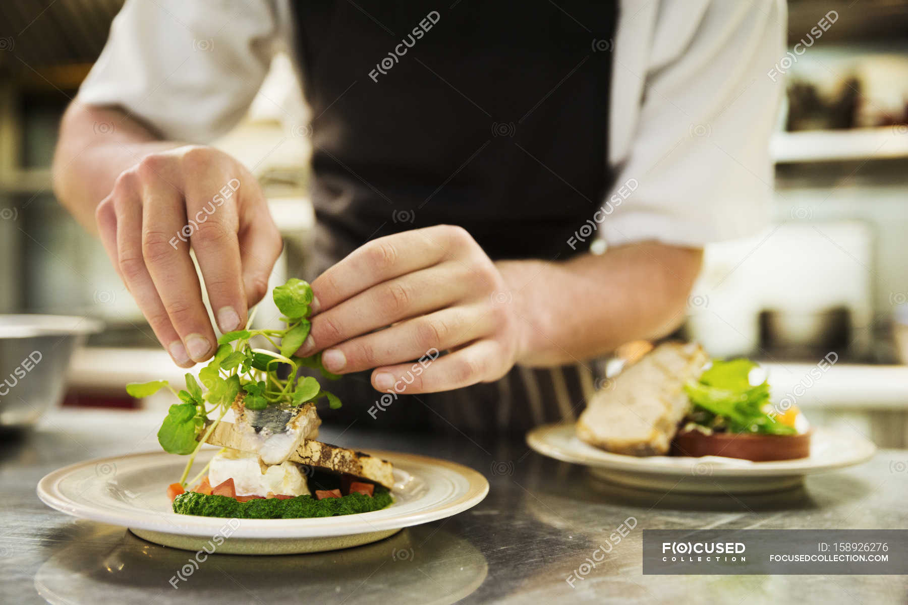 Chef In Kitchen Adding Salad Garnish Gloucestershire Portion Stock 