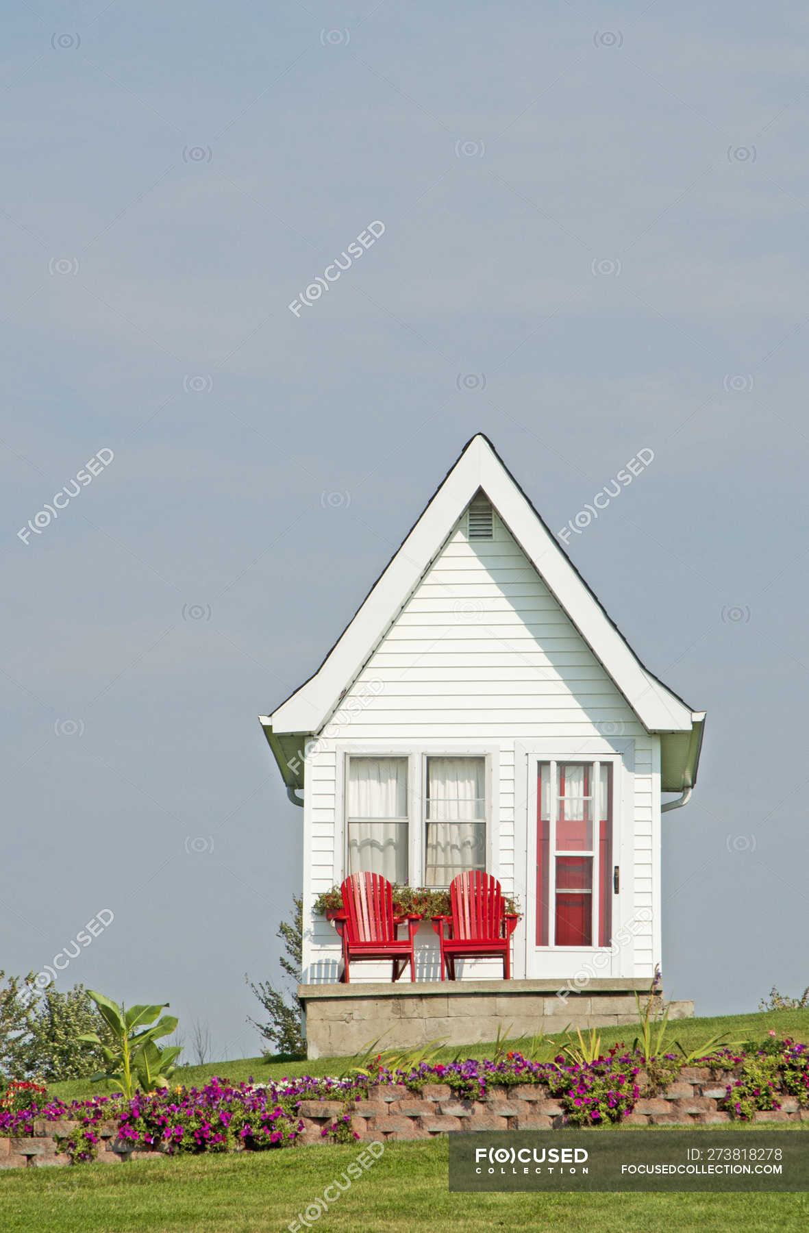 Tiny house exterior with red chairs in Kingston, Ontario, Canada — sky