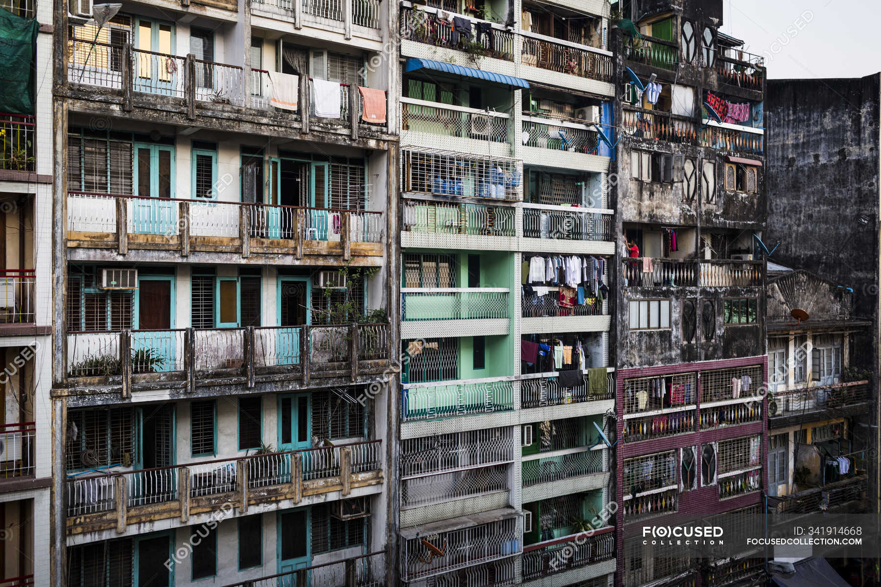 Facade of rows of rundown apartment houses with washing hanging on ...