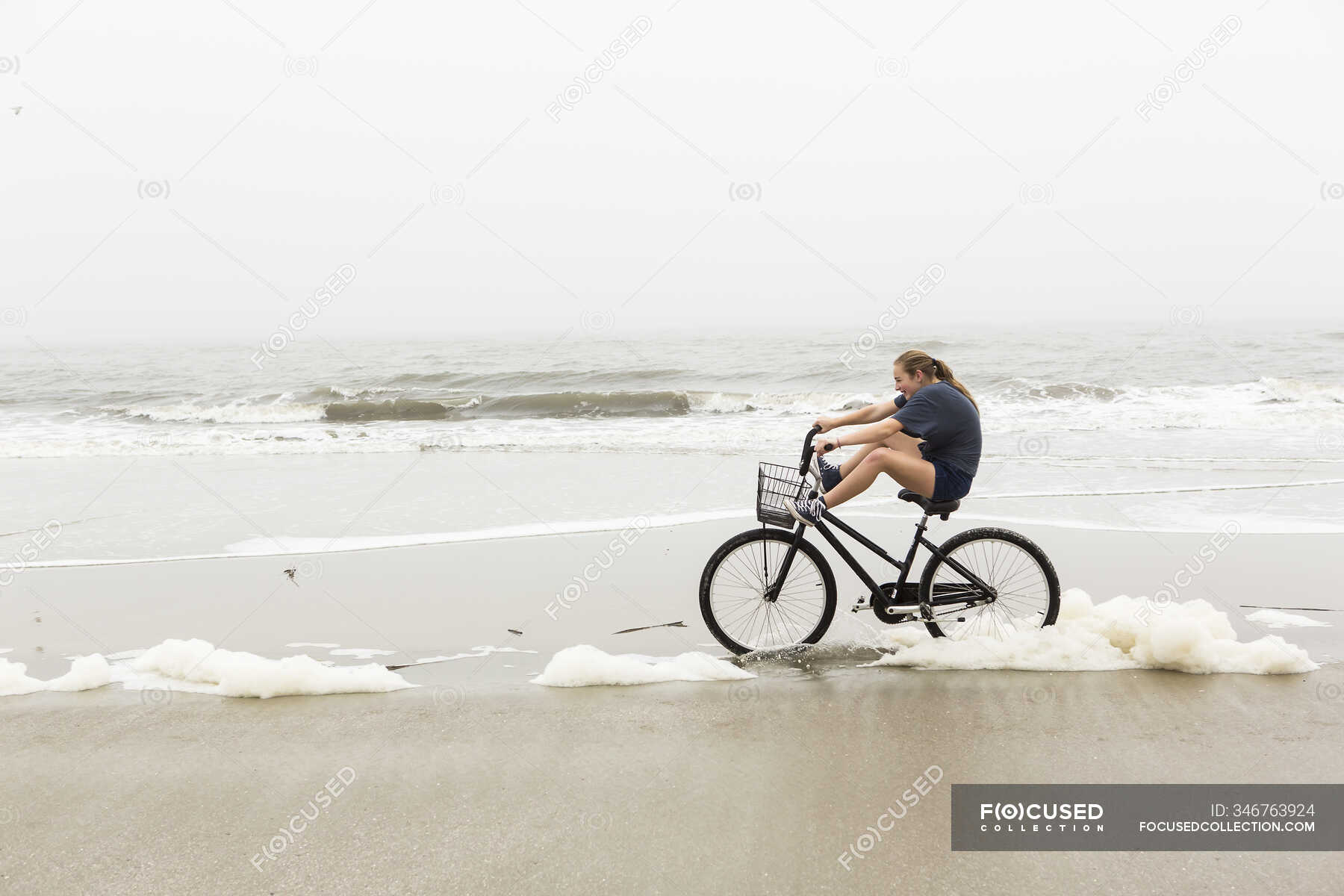 Teen girl biking on sand at the beach, St. Simons Island, — outdoors, scenics Stock