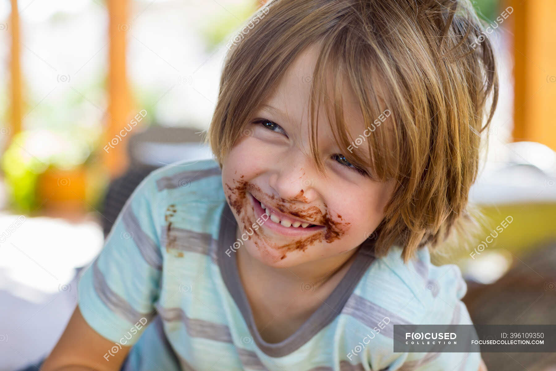 Portrait of smiling 4 year old boy with chocolate on his face playing