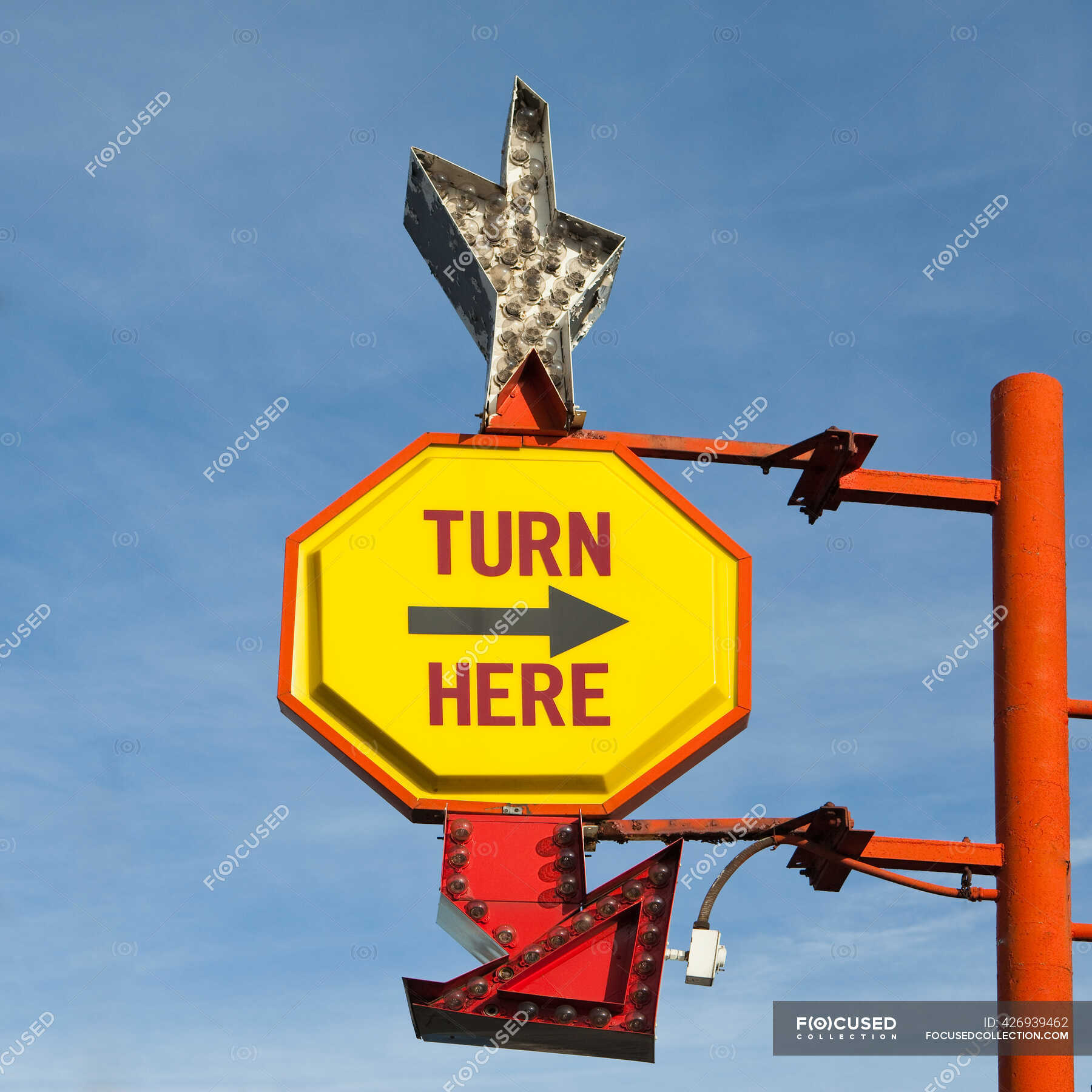 turn-here-yellow-traffic-sign-with-arrow-on-a-gantry-with-a-silver