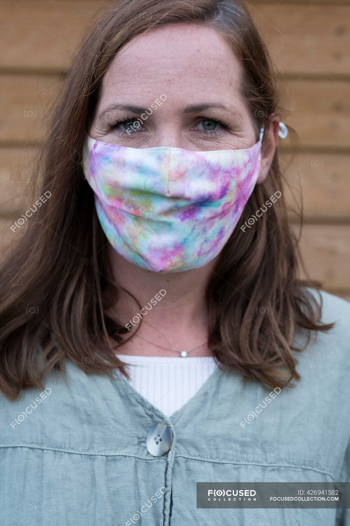 Portrait of woman with long brunette hair wearing face mask — garden ...