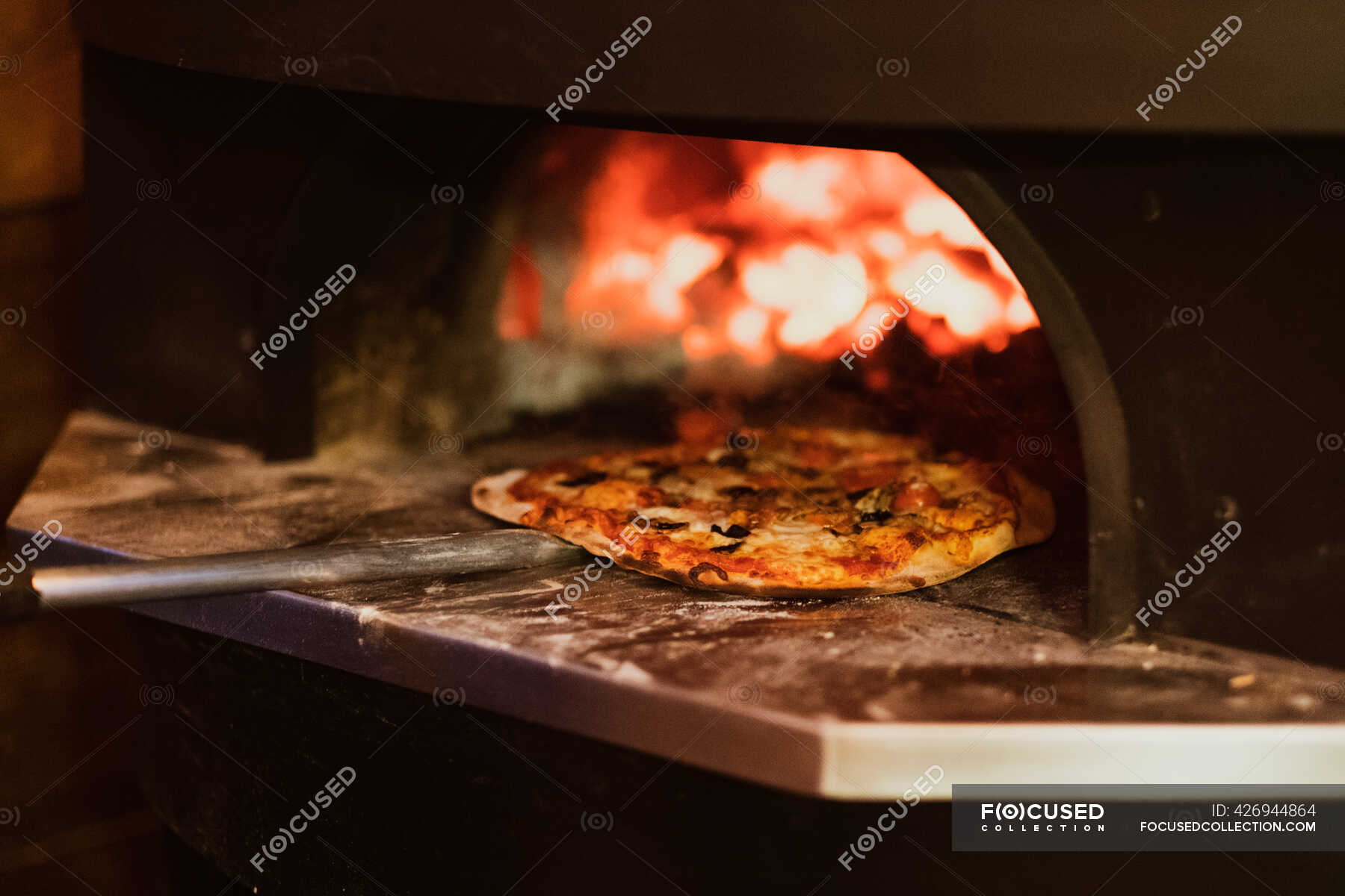 Close up of pizza in a wood-fired oven in a restaurant. — italian