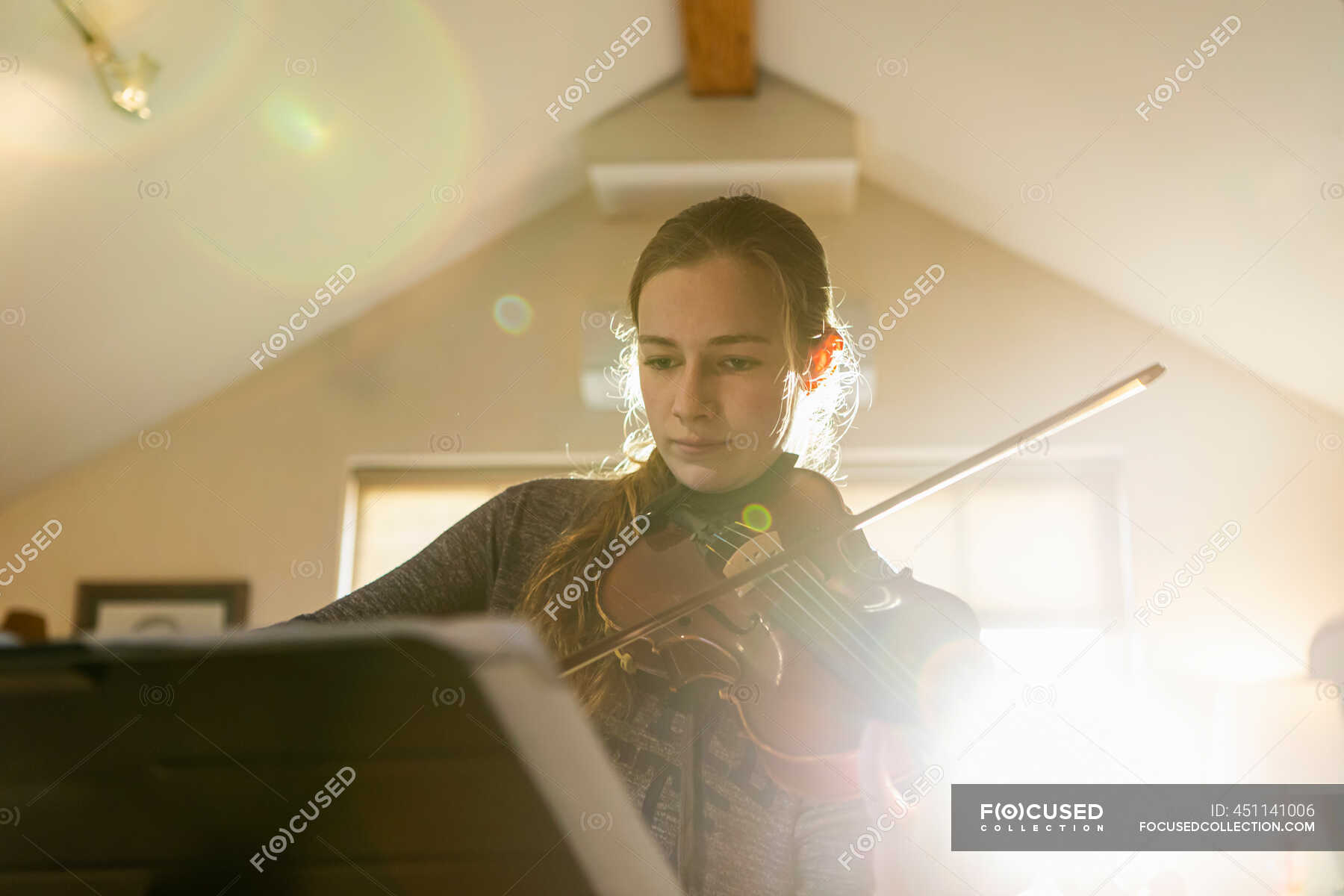 Ragazza adolescente che suona il violino nella sua camera da letto