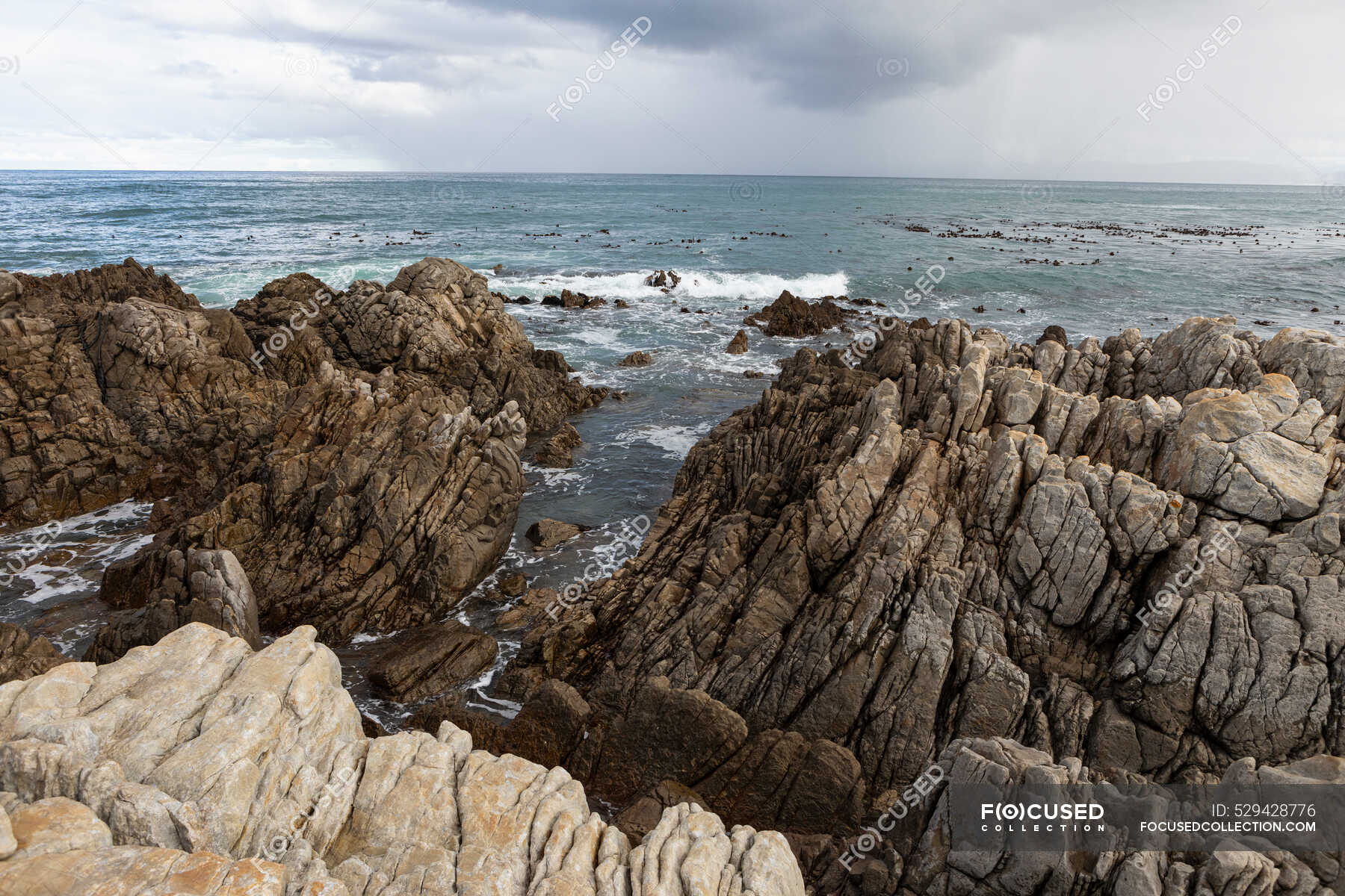 Rocky jagged coastline, eroded sandstone rock, view out to the ocean