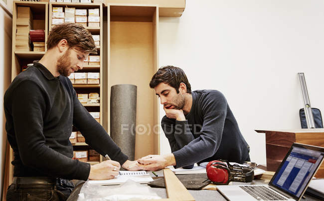 Dos personas discutiendo un diseño - foto de stock