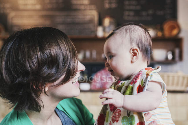 Madre y bebé pequeño mirándose el uno al otro - foto de stock