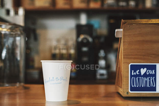 Бумажная чашка, напечатанная с названием кафе — стоковое фото