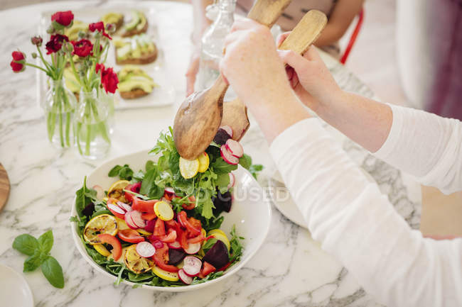 Une femme prenant une portion de salade . — Photo de stock