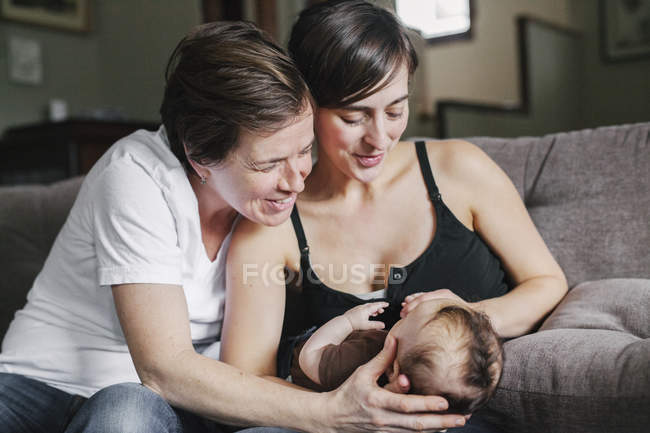Mujeres jugando con su bebé niña . - foto de stock