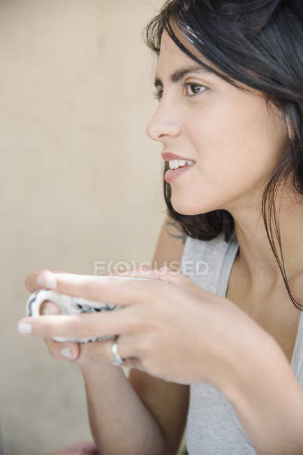 Portrait of a young woman holding a cup. — Stock Photo