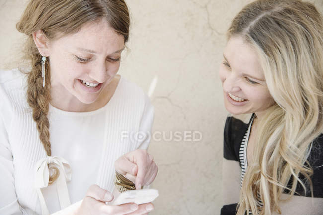 Women looking at a cell phone. — Stock Photo