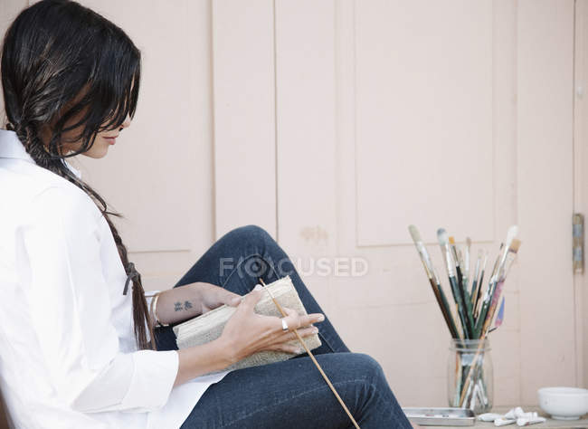 Mujer sosteniendo un cuaderno de dibujo - foto de stock