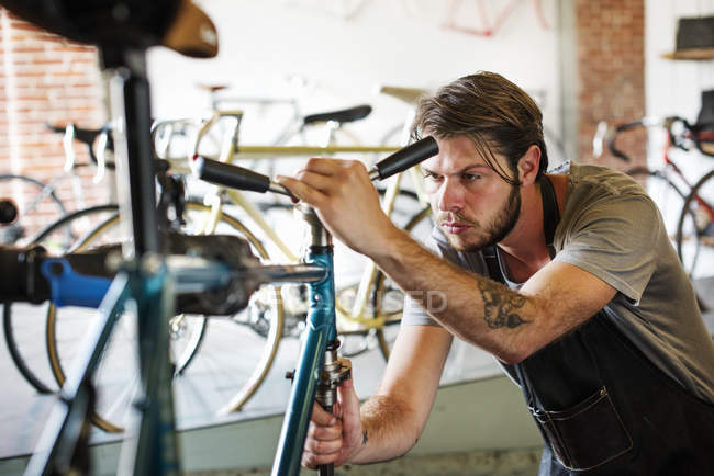 Homem verificando o quadro da bicicleta . — Fotografia de Stock