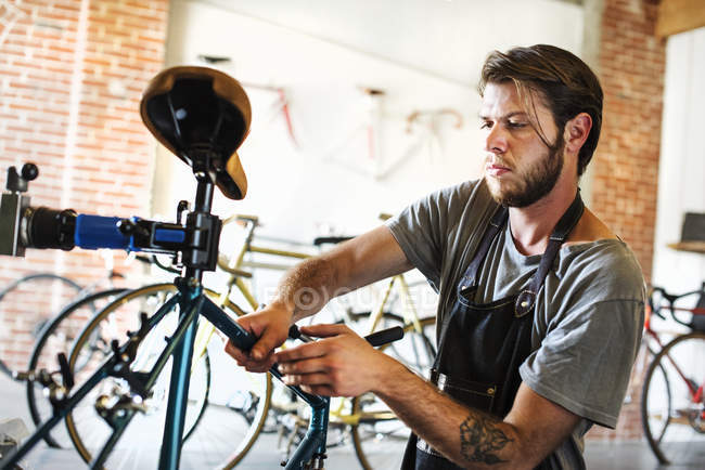 Hombre revisando el marco de la bicicleta . - foto de stock