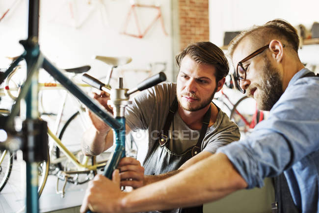 Чоловіки дивляться на велосипед . — стокове фото