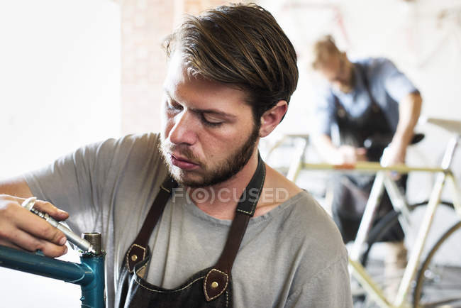 Hommes dans un atelier de réparation de cycles — Photo de stock