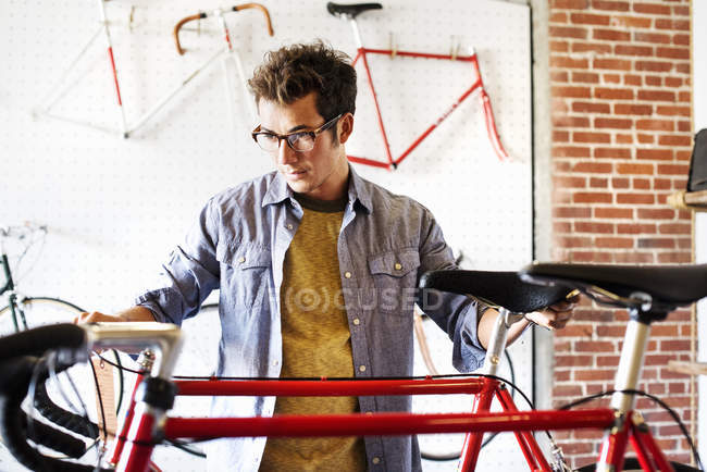 Чоловік дивиться велосипед в магазині . — стокове фото
