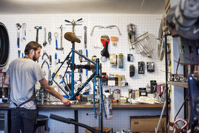 Мужчина ремонтирует велосипедный магазин . — стоковое фото