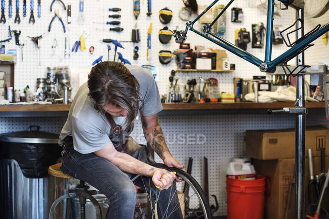 Homme réparant dans un magasin de vélos . — Photo de stock