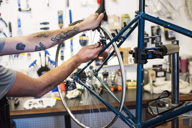 Mann repariert in Fahrradgeschäft. — Stockfoto