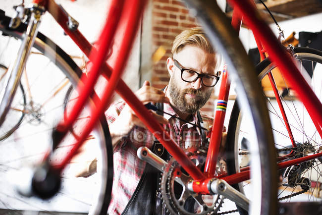 Homem de reparação de bicicleta na loja — Fotografia de Stock