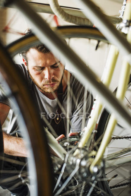 Hombre reparando una bicicleta - foto de stock